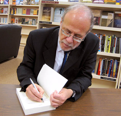 Richard Bauckham signs a book. Photo by Ferrell Jenkins.