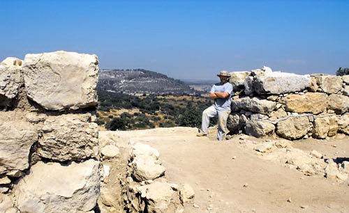 Luke is standing in the "Philistia Gate" with his left foot in the Iron Age threshold. Azekah can be seen in the distance.